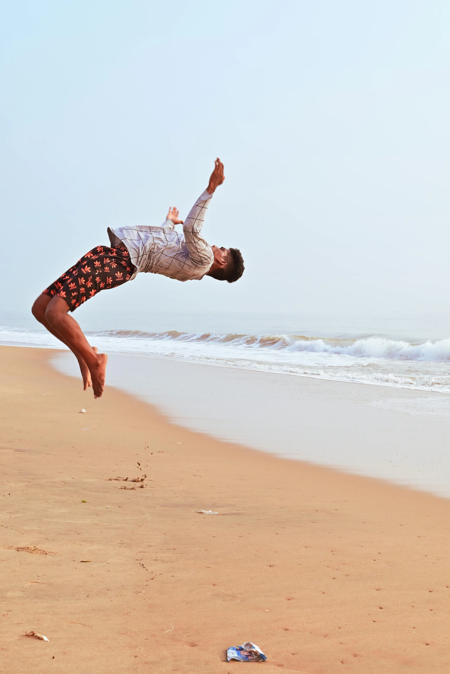 an image of man jumping in the air on the beach