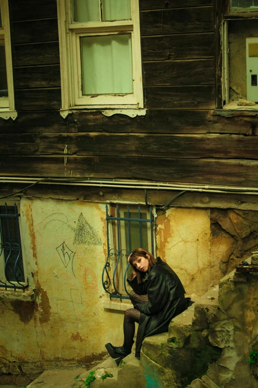 a woman is sitting on a set of steps outside a building