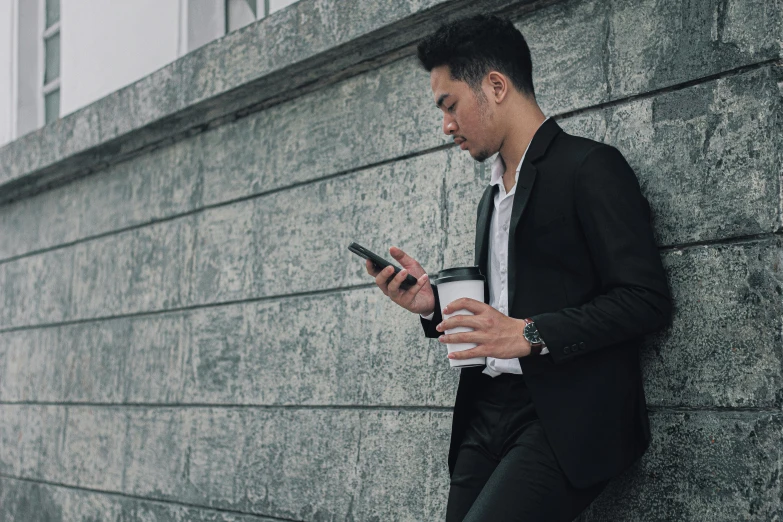 a person in a suit looks at his cellphone