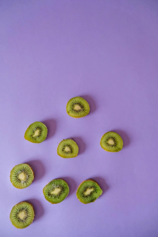kiwi slices are shown on a purple surface