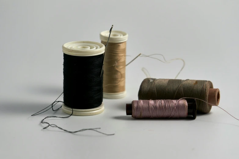 a white counter topped with two spools of thread