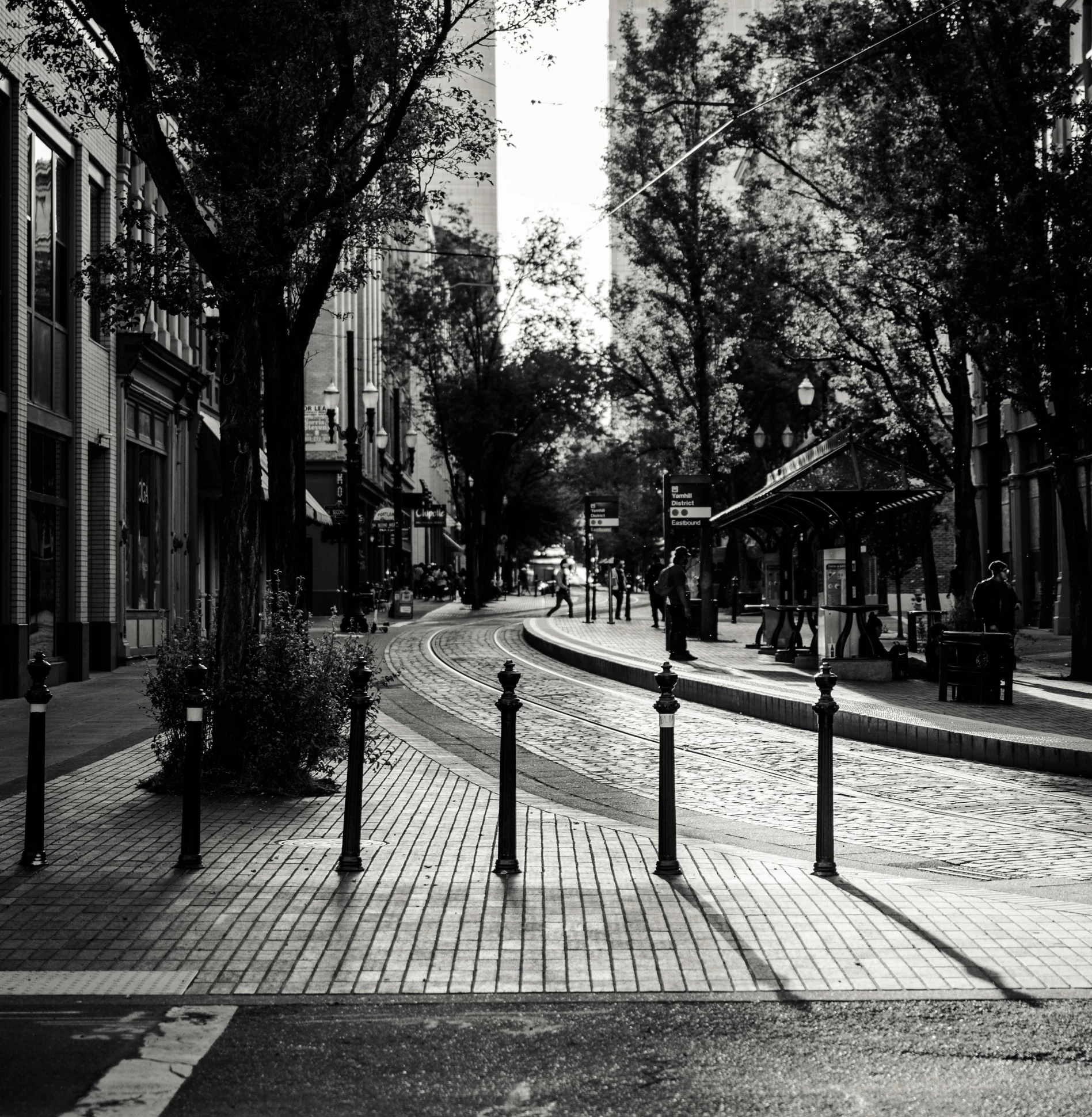 black and white pograph of a street with people walking along it