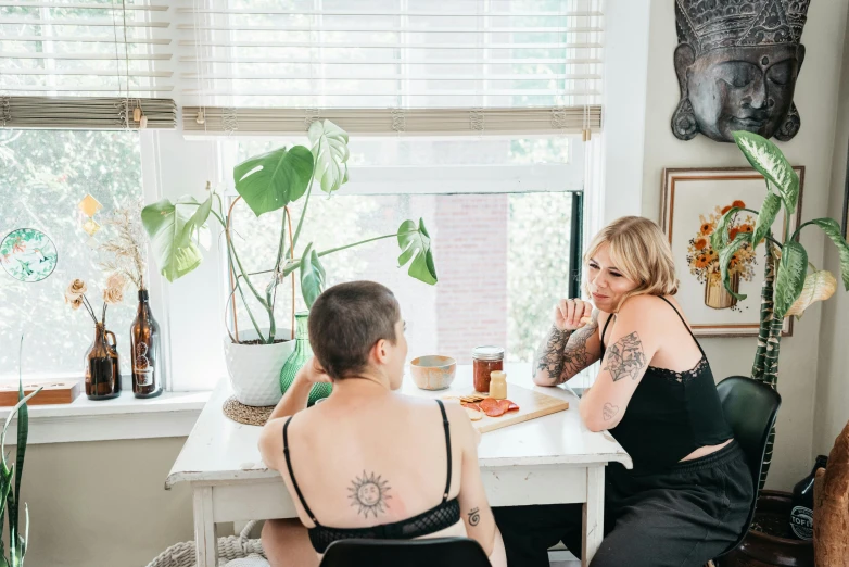 a woman with tattoos is eating food at a table