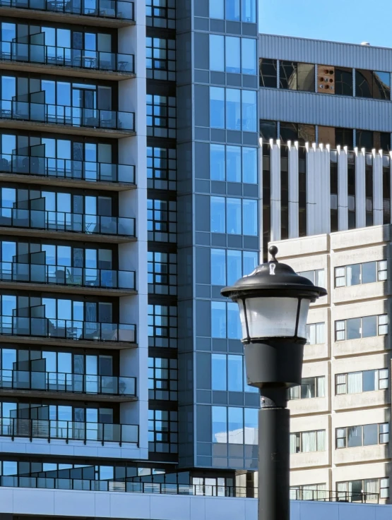 a lamp post with one light in the middle by a building