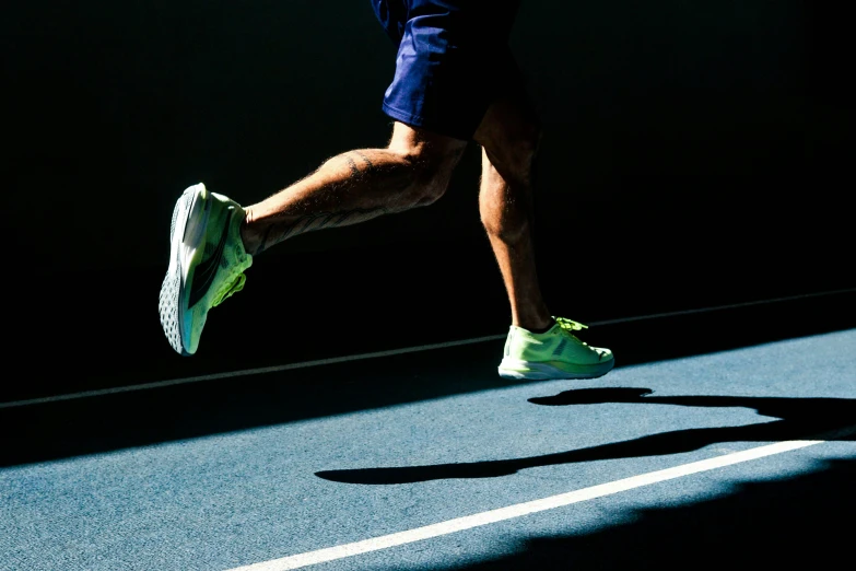 a person in blue shorts and sneakers running on a street