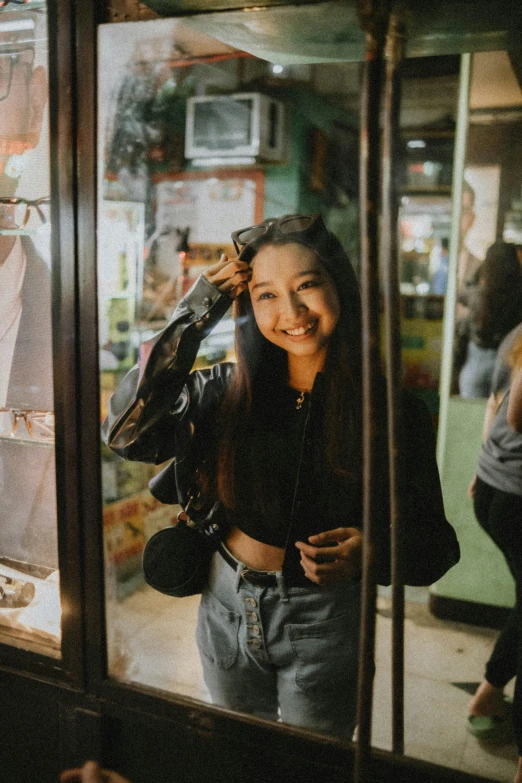 a smiling woman standing next to the window