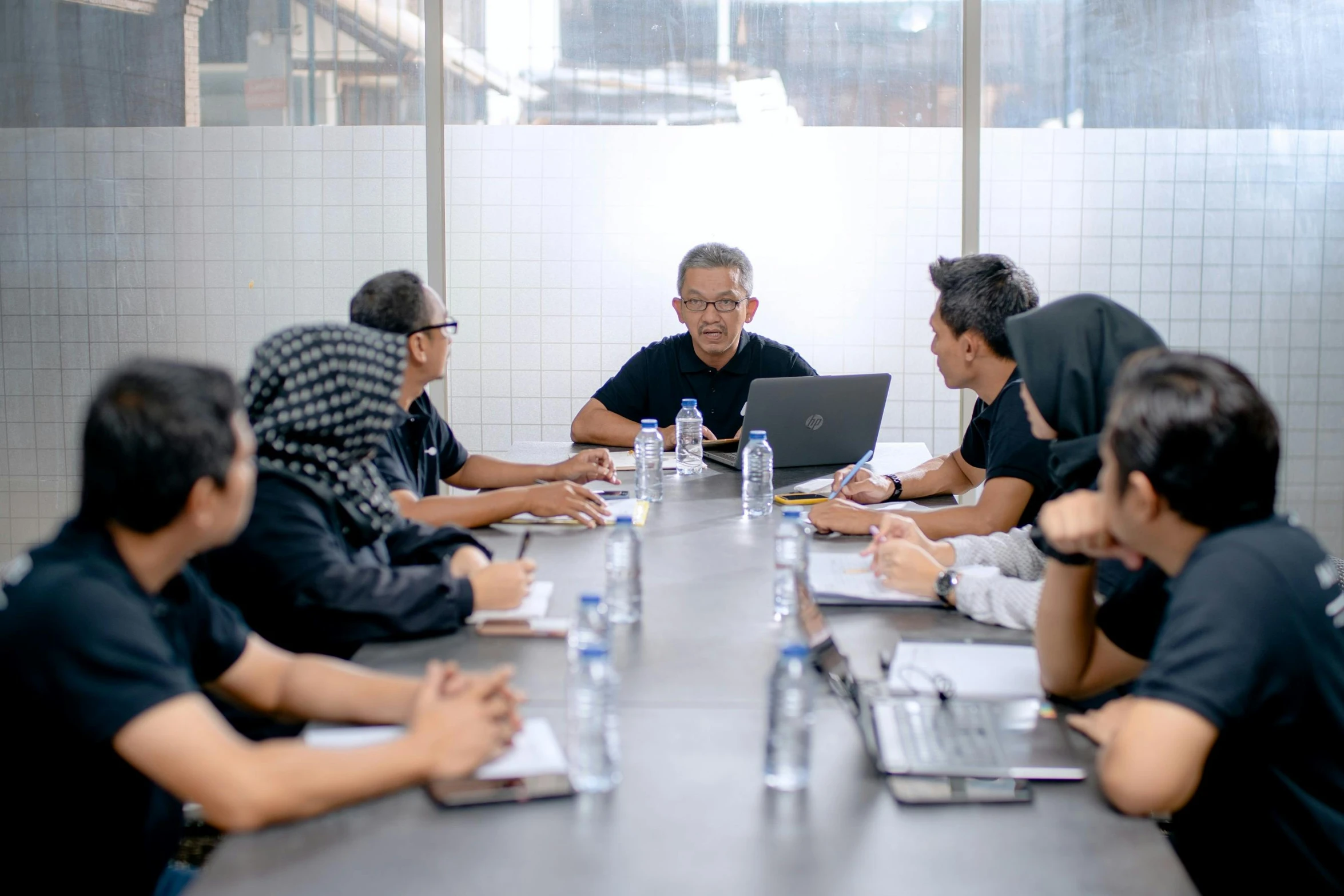 a group of men are in a meeting room