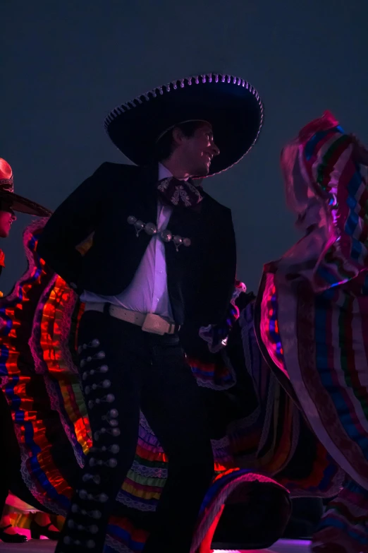 a man in a mexican outfit riding on top of a horse