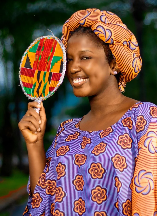 a young woman in traditional dress is holding a lollipop