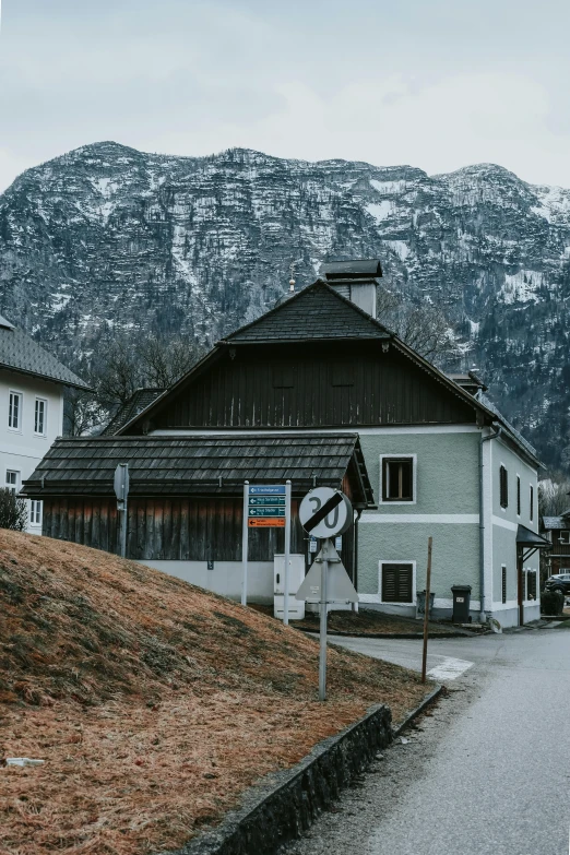 the side view of a house with a hill in the background