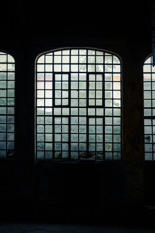 a building with three windows, and some dark walls