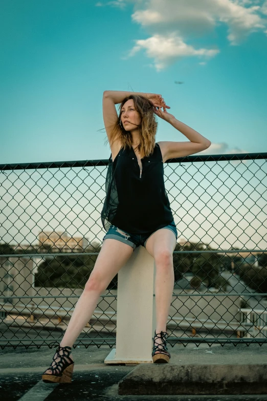 a girl leaning on a fence and posing for the camera