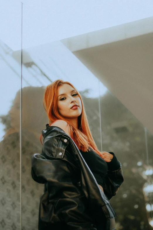 a woman with long red hair is standing in front of a mirror