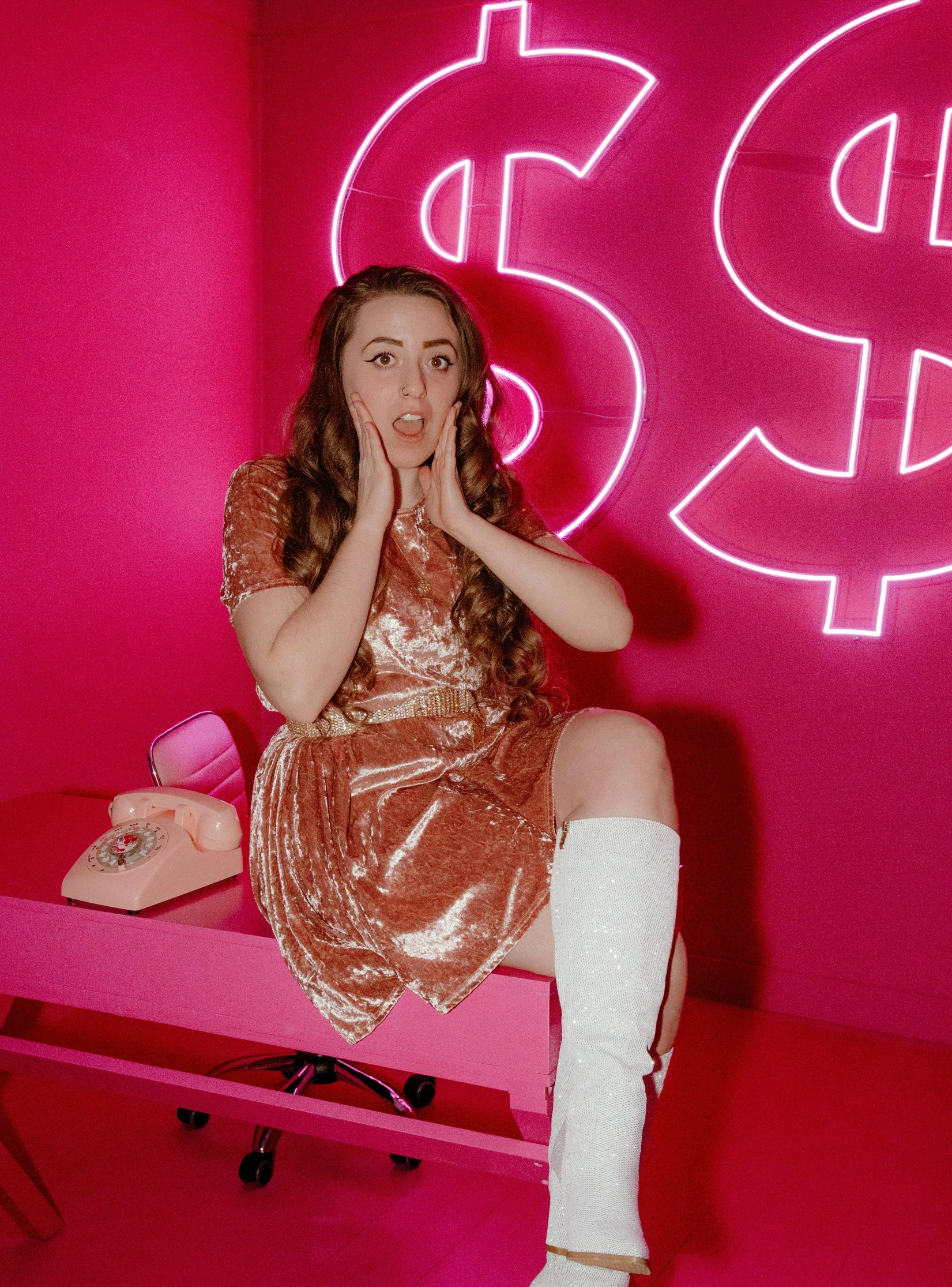 a girl sitting on top of a pink table