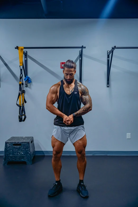 a man in shorts and tank top holding hands on his hips