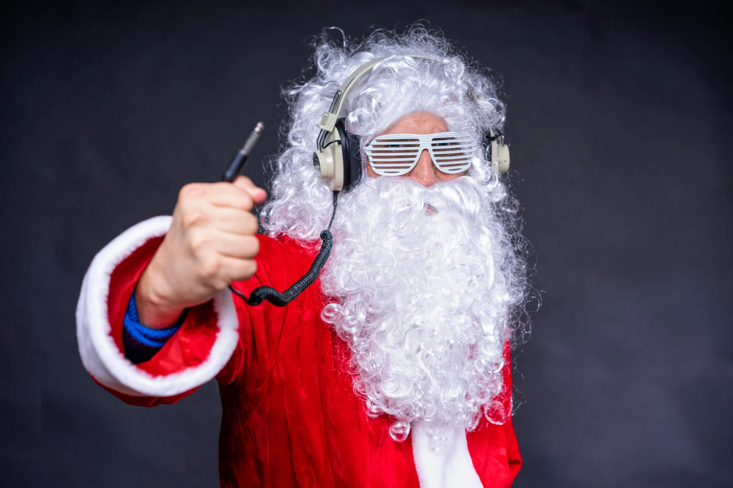 a man dressed as santa claus holding a microphone in his right hand