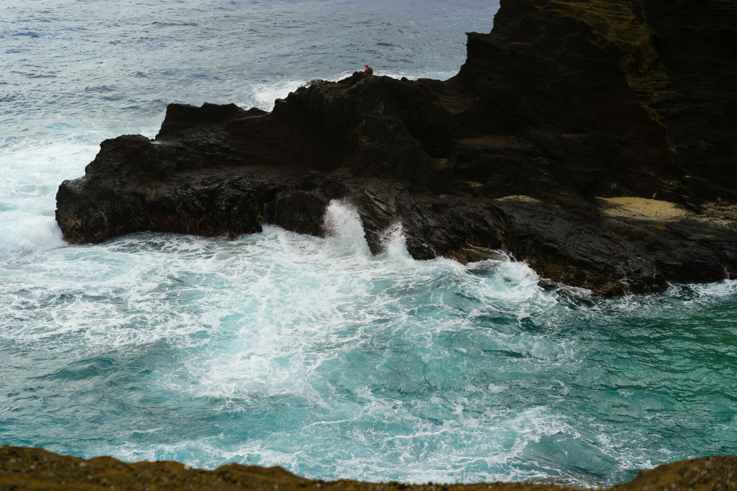 a person is on a rock near the water