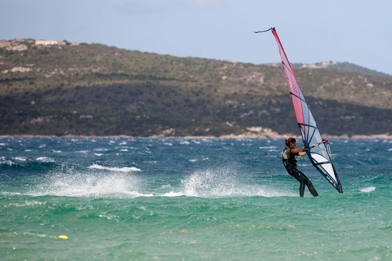 the man is wind surfing in the open ocean