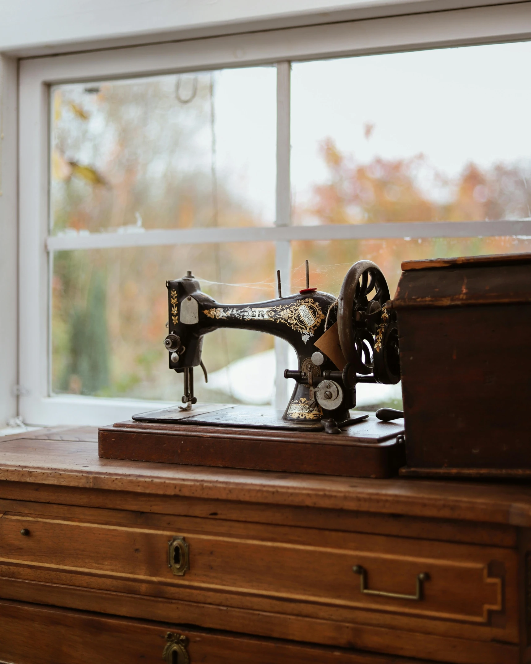 a sewing machine sits on an antique desk