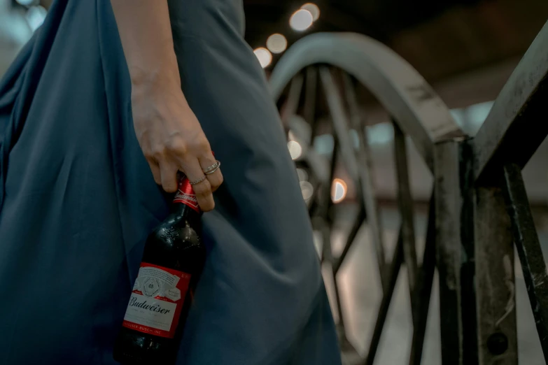 a lady with a ring holds onto a large bottle