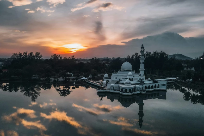 the sun rises above an island on a lake