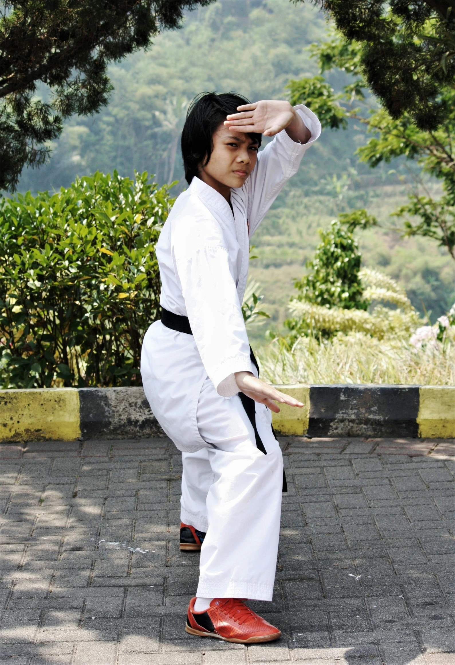 a man dressed in white and black performing karate moves