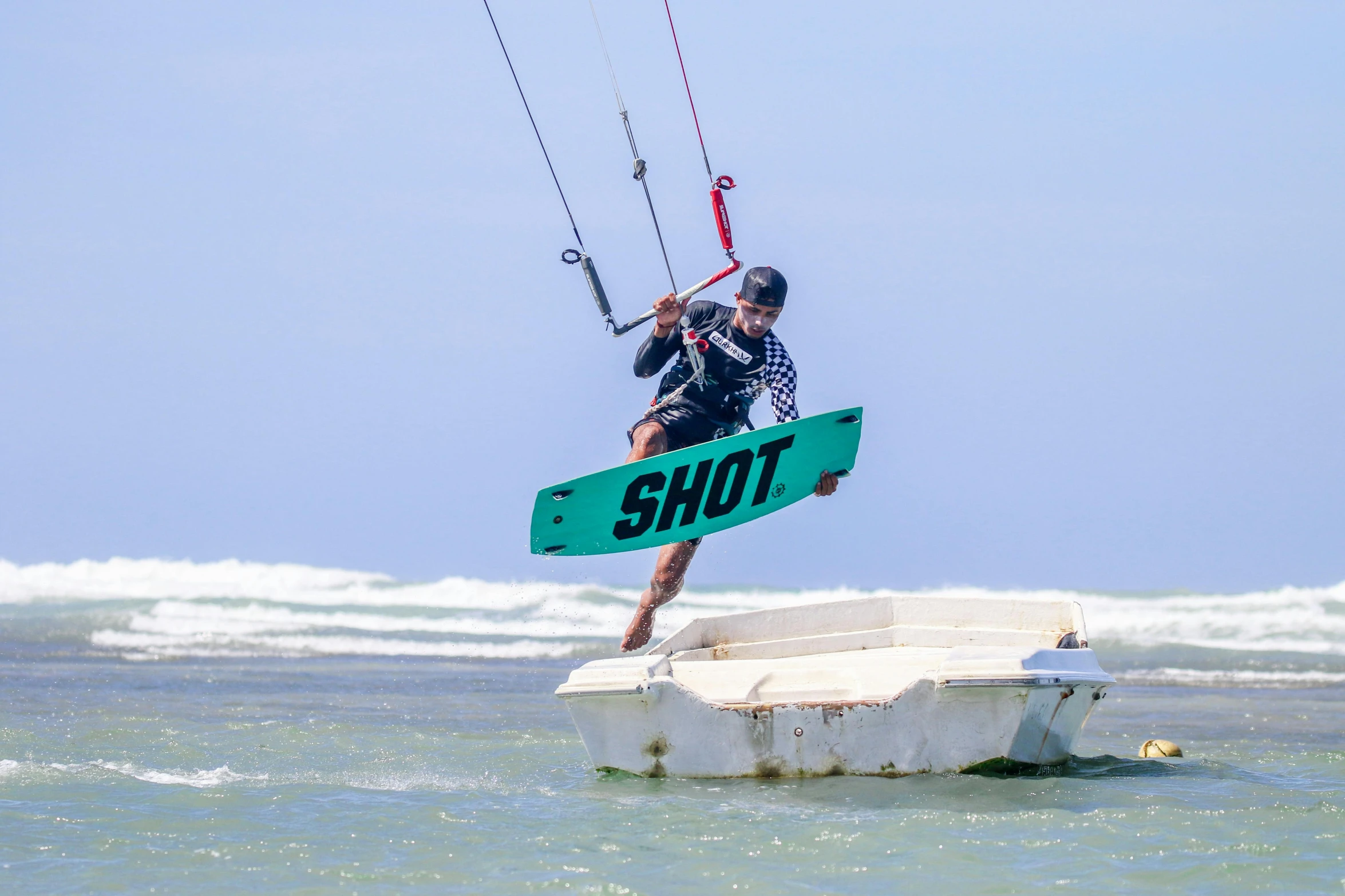 man holding a surfboard while flying above the water