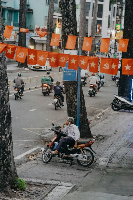 motorcyclist on a city street with orange and white flags