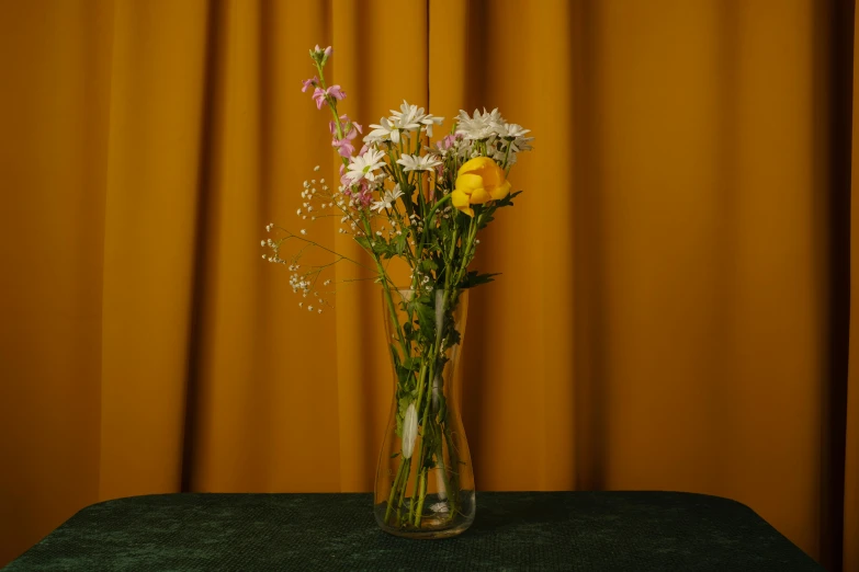 a vase full of flowers on a green table cloth