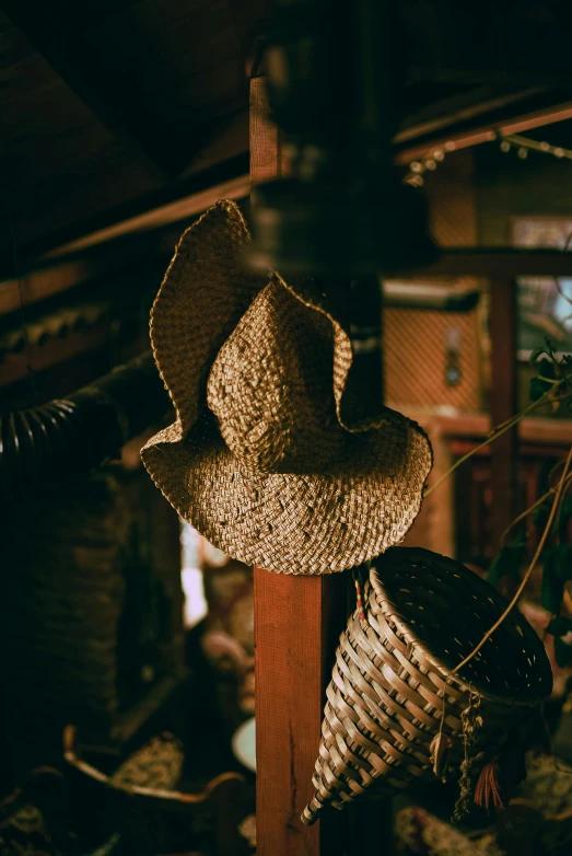 a few hats are hanging from the wooden post