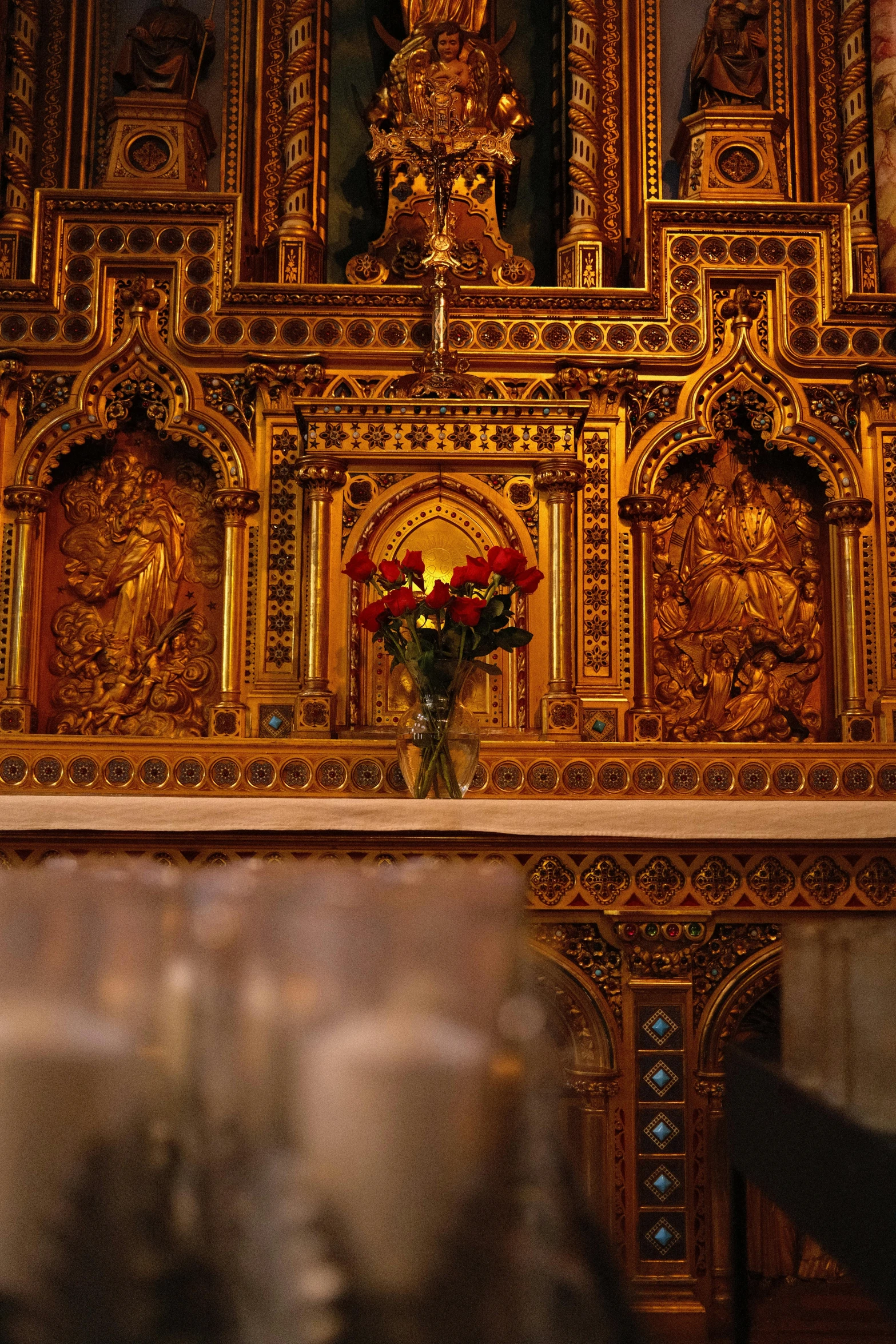 the flowers are in front of a very ornate alter