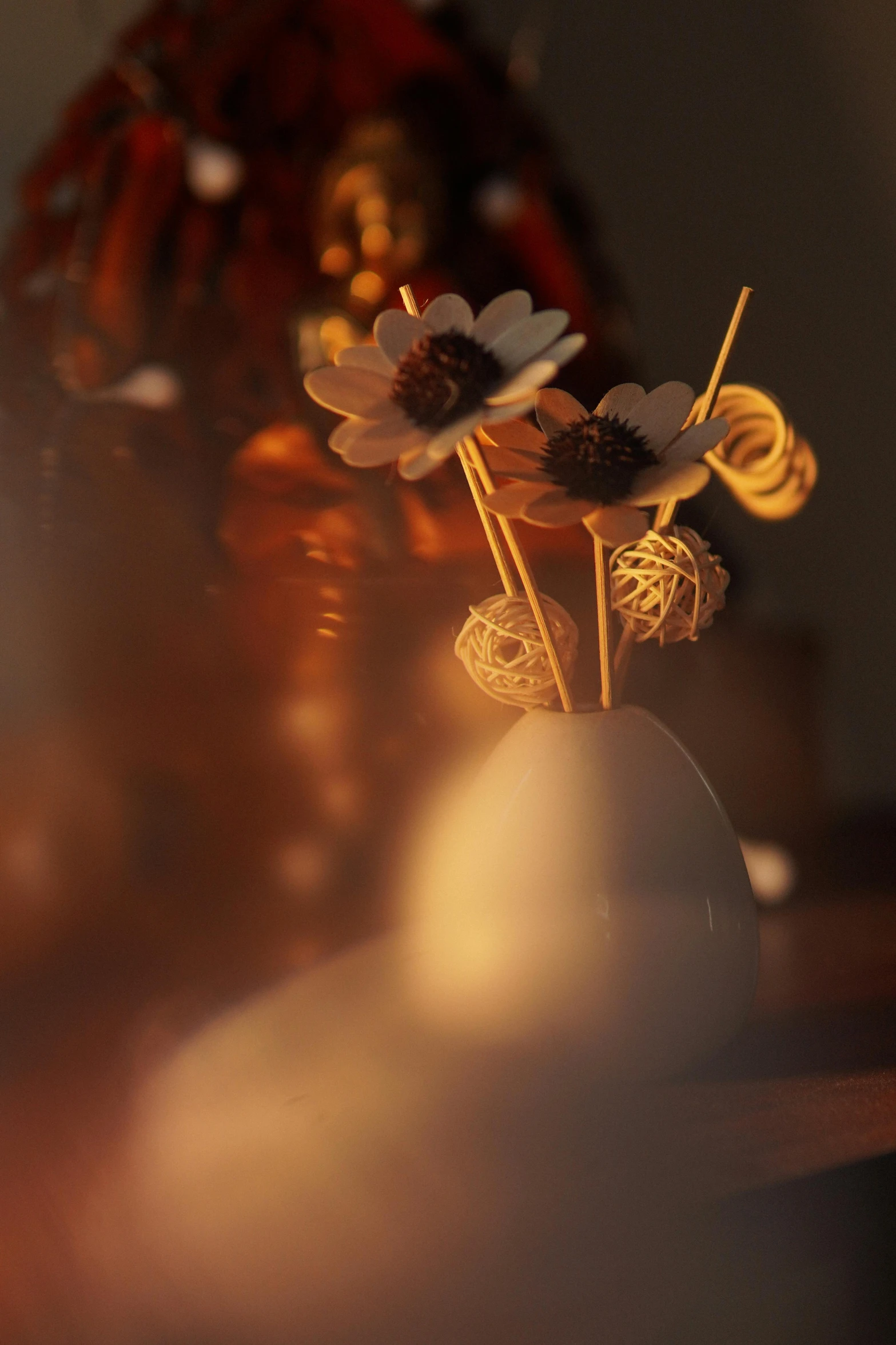 small white vase containing flowers and bees on a wooden table