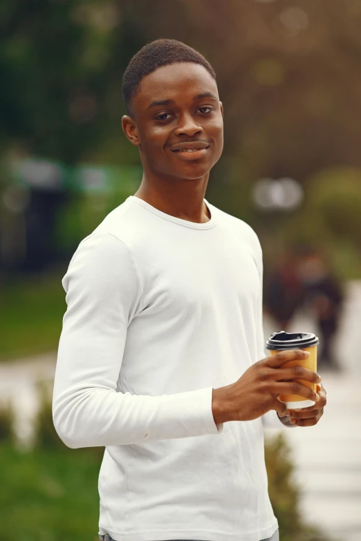 a person holding a coffee cup in a park