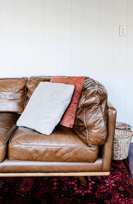 a small leather couch is placed on an area rug