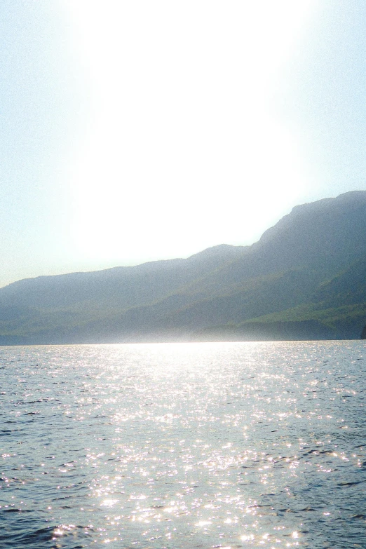 water and hills are shown with a clear sky