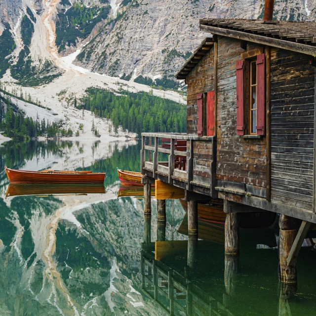 two boats on the water in front of a cabin