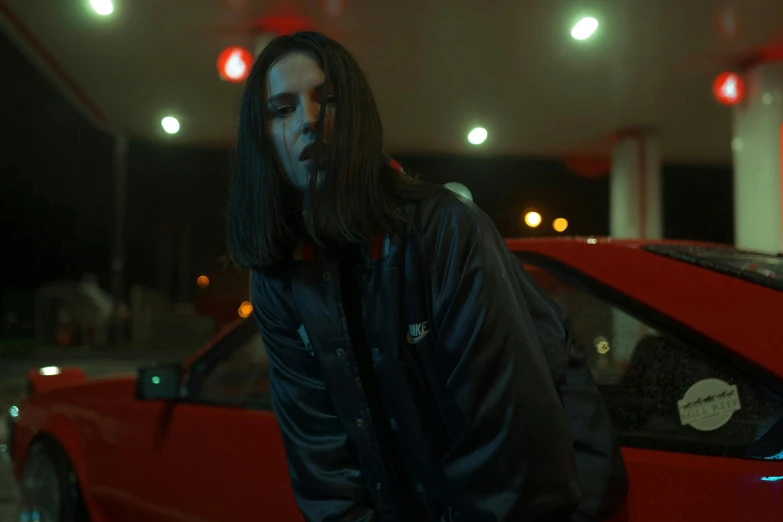 the man is standing next to his car with one eye open