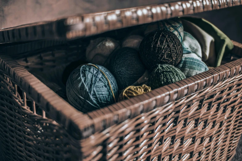 some balls of yarn and balls of thread in a basket