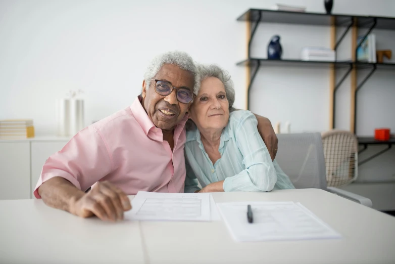 an elderly couple posing for a po on the table