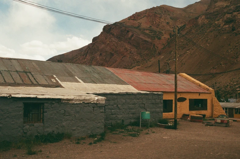 an old run down building stands near a mountain
