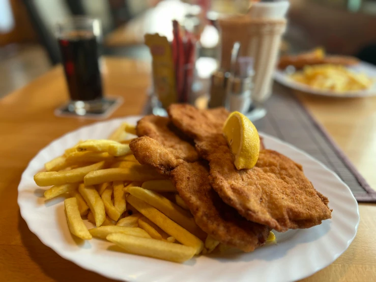 a plate with fried fish and french fries and a drink