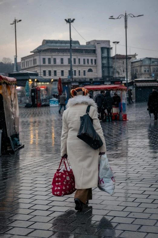 a woman walking down the street carrying bags