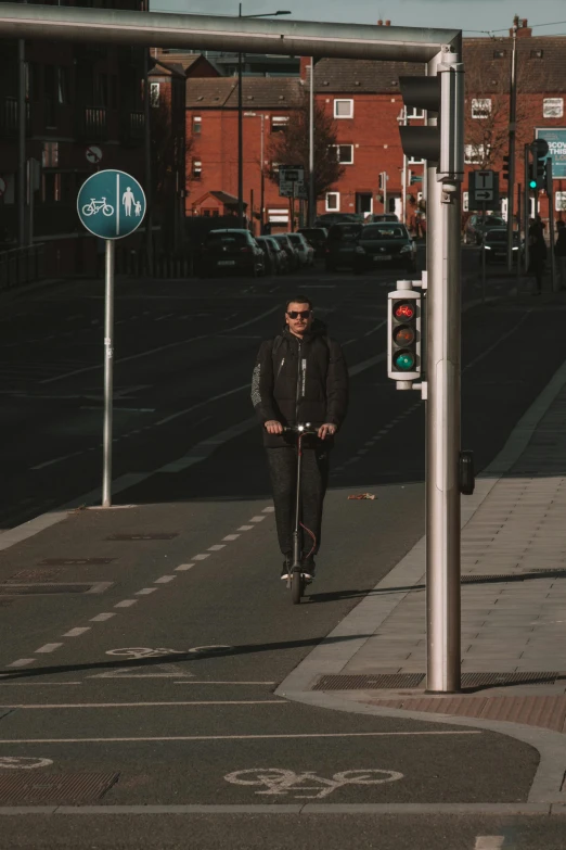 a man riding a scooter next to a traffic light