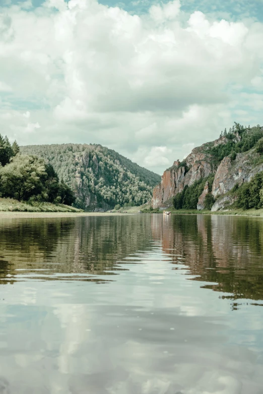 calm calm water in front of hills and clouds