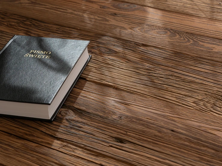 a book is lying on top of a wooden table