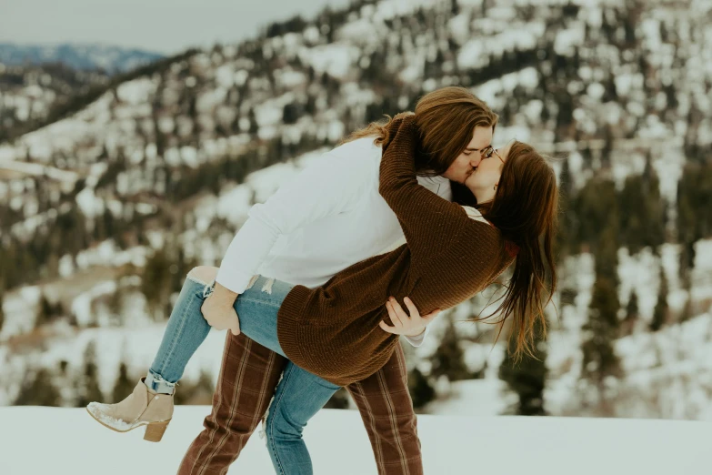 the young couple is enjoying their time in the snow