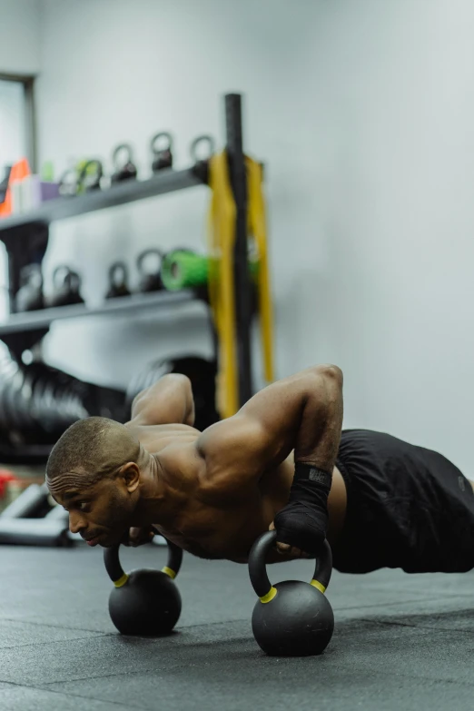 a man doing h ups with dumbbells in the gym