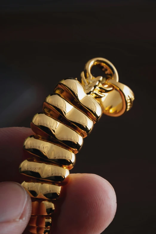 a man holds out an elegantly shiny gold charm