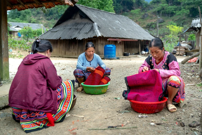 three woman sitting next to each other on the ground