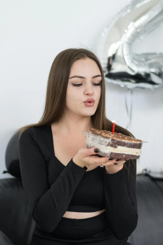a girl eating cake in her home, looking surprised